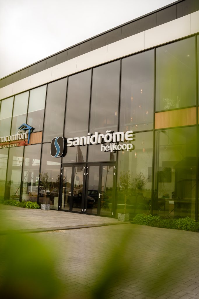 Voorgevel van Sanidrõme Heijkoop in Oude Tonge – moderne badkamershowroom met glazen pui en strak logo.