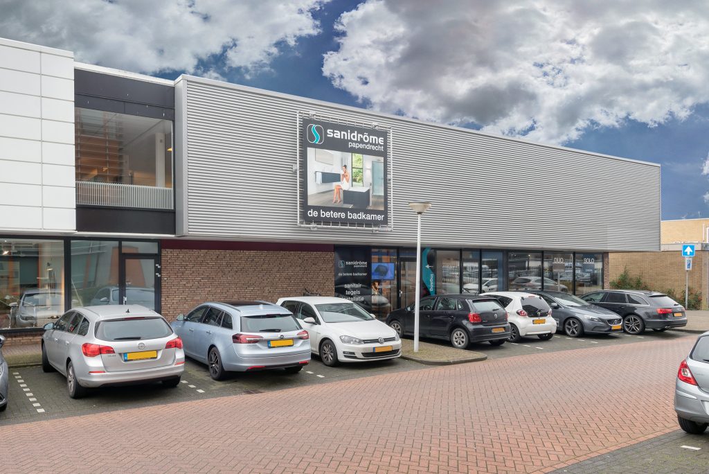 Vooraanzicht van Sanidrõme Papendrecht met showroomentree en parkeerplaatsen