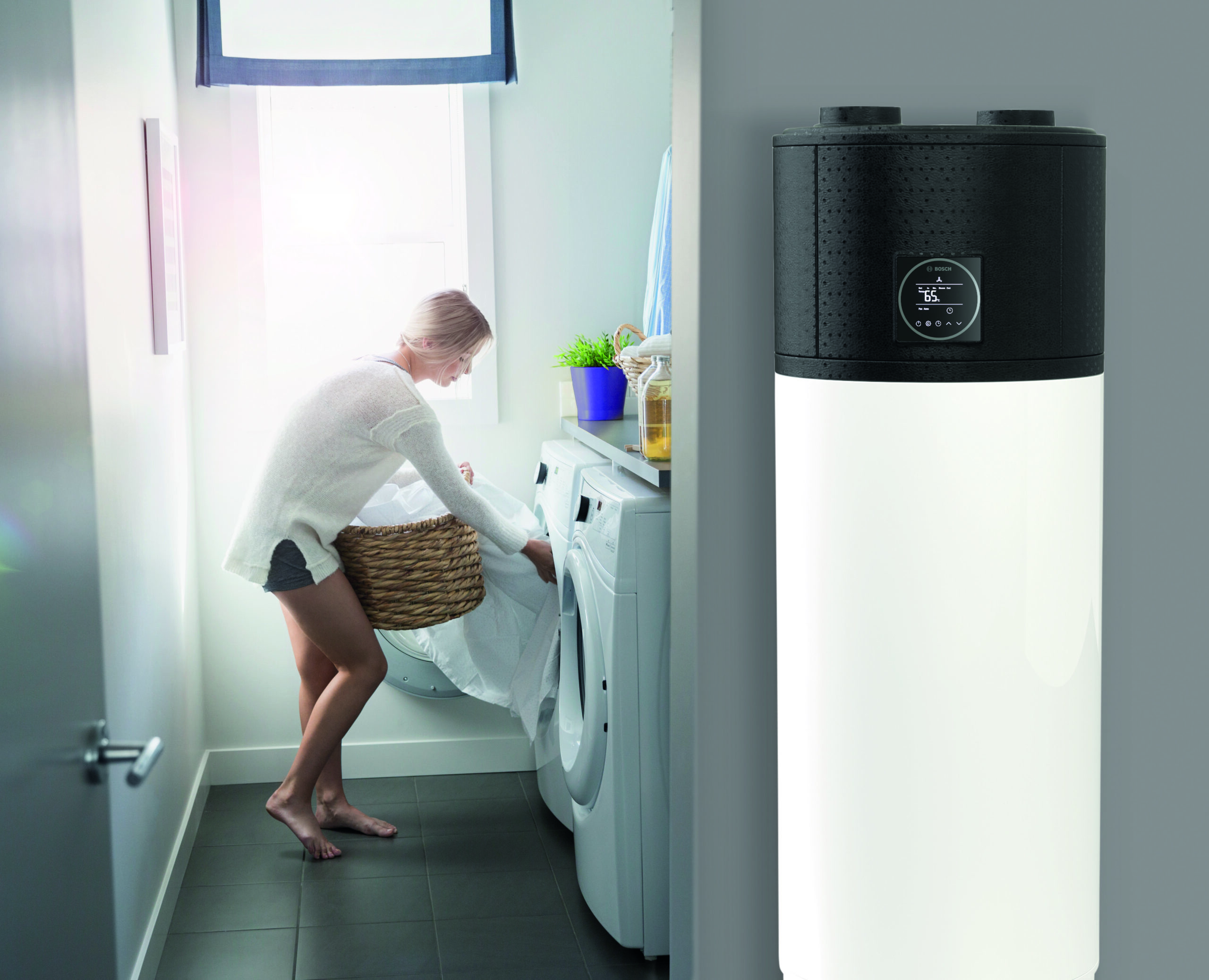 Woman removing sheets from dryer in laundry room